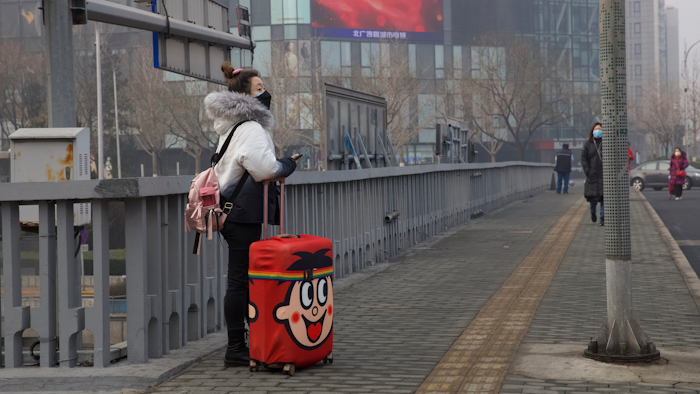 A traveler stands on a bridge in Beijing, China.