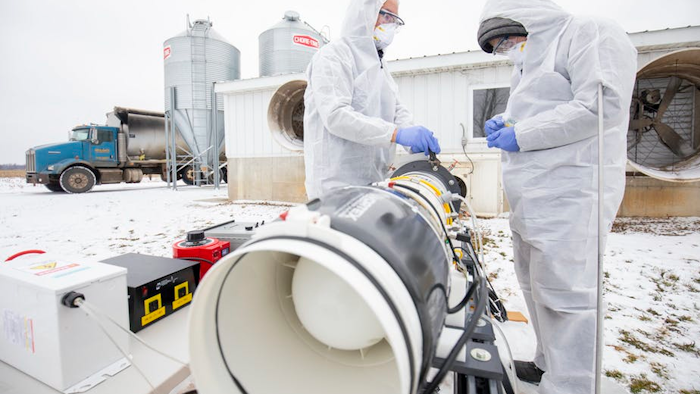 Researchers Tian Xia and Zijie Lin test a plasma prototype for preventing airborne transmission of porcine reproductive and respiratory syndrome virus at a Michigan pig farm.