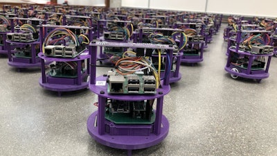 One hundred small robots line up in the laboratory.