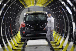 A Fiat factory worker in front of a 500L car, Kragujevac, Serbia, April 16, 2012.