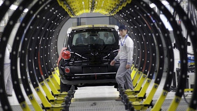 A Fiat factory worker in front of a 500L car, Kragujevac, Serbia, April 16, 2012.