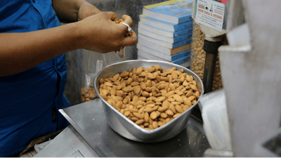 In this June 22, 2019 file photo, a shopkeeper weighs California almonds for a customer at a shop in New Delhi, India. Almonds used to have about 170 calories per serving, then researchers said it was really more like 130. A little later, they said the nuts may have even less. The shifting numbers for almonds show how the figures stamped on nutrition labels may not be as precise as they seem.