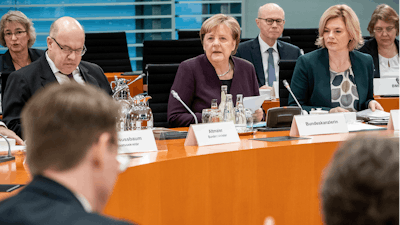 German Chancellor Angela Merkel, center, speaks alongside Peter Altmaier, Federal Minister of Economics and Energy, left, and Julia Klöckner, Federal Minister of Food and Agriculture, at the beginning of a meeting of the Federal Government with representatives of the food industry in Berlin, Germany, Monday, Feb.3, 2020.