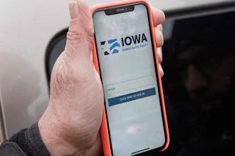 Precinct captain Carl Voss of Des Moines displays the Iowa Democratic Party caucus reporting app on his phone outside of the Iowa Democratic Party headquarters in Des Moines, Iowa, Tuesday, Feb. 4, 2020.