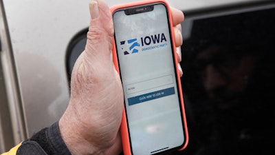 Precinct captain Carl Voss of Des Moines displays the Iowa Democratic Party caucus reporting app on his phone outside of the Iowa Democratic Party headquarters in Des Moines, Iowa, Tuesday, Feb. 4, 2020.
