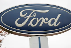 In this Oct. 20, 2019, file photo, the company logo stands over a long row of unsold vehicles at a Ford dealership in Littleton, Colo.