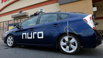 In this Aug. 16, 2018 file photo, a self-driving Nuro vehicle parks outside a Fry's supermarket in Scottsdale, Ariz.