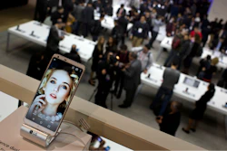In this Feb. 27, 2017 file photo, people crowd at the LG stand during the Mobile World Congress wireless show in Barcelona, Spain.