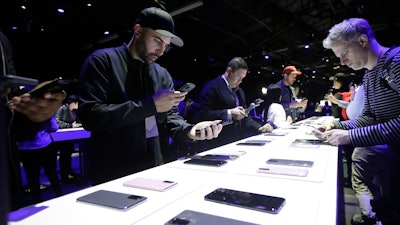 People look at different Samsung Galaxy S20 5G phones displayed at the Unpacked 2020 event in San Francisco, Tuesday, Feb. 11, 2020.