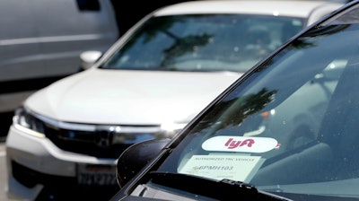 In this July 9, 2019, file photo a Lyft ride-share car waits at a stoplight in Sacramento, Calif.