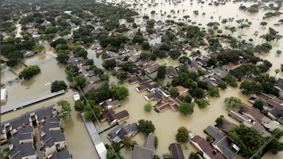 In this Aug. 29, 2017, file photo, water from Addicks Reservoir flows into neighborhoods from floodwaters brought on by Tropical Storm Harvey in Houston. A federal judge ruled the U.S. Army Corps of Engineers was not liable for damages to thousands of Houston homes that were inundated by two federally owned reservoirs in the days following Hurricane Harvey because they would have flooded regardless. U.S. Judge Loren A. Smith of the Court of Federal Claims dismissed the case on Tuesday, Feb. 18, 2020.