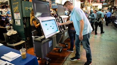 In this June 13, 2019, file photo, Steve Marcinkus, an Investigator with the Office of the City Commissioners, demonstrates the ExpressVote XL voting machine at the Reading Terminal Market in Philadelphia.