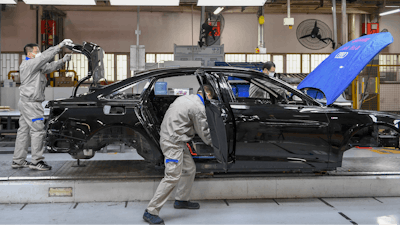 In this Feb. 17, 2020, file photo released by Xinhua News Agency, workers assemble Audi A6 L cars at a workshop of FAW-Volkswagen Automobile Co., Ltd. in Changchun, northeast China's Jilin Province.Factories that make the world's smartphones, toys and other goods are struggling to reopen after a virus outbreak idled China's economy. But even with the ruling Communist Party promising help, companies and economists say it may be months before production is back to normal.