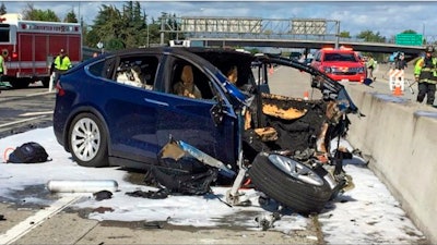 In this March 23, 2018, file photo provided by KTVU, emergency personnel work a the scene where a Tesla electric SUV crashed into a barrier on U.S. Highway 101 in Mountain View, Calif.