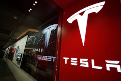 This Feb. 9, 2019, file photo shows a sign bearing the company logo outside a Tesla store in Cherry Creek Mall in Denver.