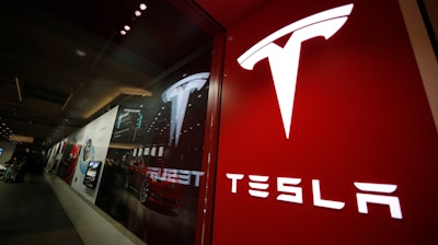 This Feb. 9, 2019, file photo shows a sign bearing the company logo outside a Tesla store in Cherry Creek Mall in Denver.