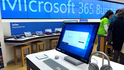 In this Jan. 28, 2020, file photo a Microsoft computer is among items displayed at a Microsoft store in suburban Boston. Microsoft says its supply chain is being hurt by the virus outbreak in China and will return to normal operations at a slower pace than it expected a month ago.