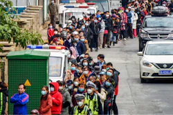 In this Jan. 29, 2020, file photo, people line up to buy face masks from a medical supply company in Nanning in southern China's Guangxi Zhuang Autonomous Region.