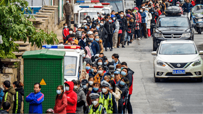 In this Jan. 29, 2020, file photo, people line up to buy face masks from a medical supply company in Nanning in southern China's Guangxi Zhuang Autonomous Region.