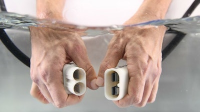 When the niobium connector enters in contact with the water, it creates its own thin isolating layer, which gets scraped off when the connection is made. Once disconnected, the layer instantly regenerates.