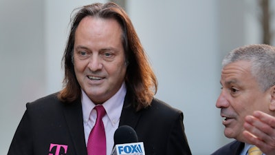 T-Mobile chief executive John Legere speaks to reporters as he leaves the courthouse in New York.