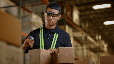 A warehouse worker shows off some new wearable devices developed by Zebra Technologies for scanning and tracking products.