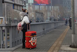 A traveler stands on a bridge in Beijing, China.