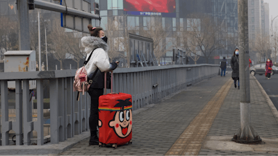 A traveler stands on a bridge in Beijing, China.