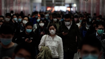 Residents of Hong Kong wear masks as they make their commutes.