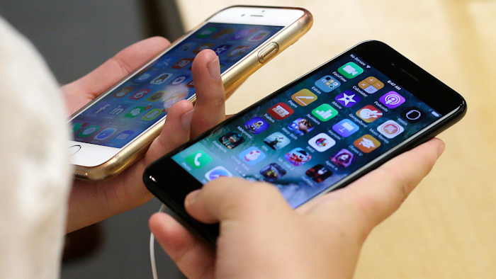 In this Sept. 16, 2016 file photo, a customer compares her iPhone 6, left, with an iPhone 7 at an Apple Store in Chicago.