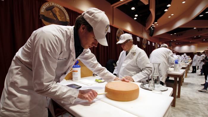 Judge Douwe Dijkstra pulls out a piece of Appenzeller cheese at the biennial World Championship Cheese Contest, Tuesday, March 3, 2020, at the Monona Terrace Convention Center in Madison, Wis.