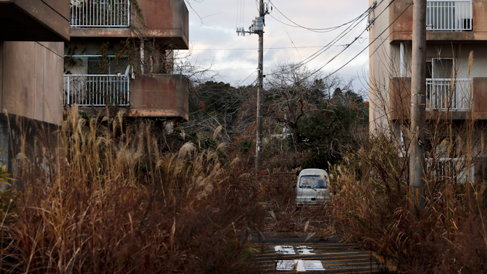 In this Dec. 3, 2019, file photo, weeds grow in an abandoned apartment complex, in Futaba, Fukushima prefecture, Japan.