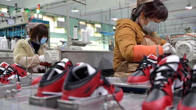 In this photo taken on Feb. 22, 2020 and released by Xinhua News Agency, workers wear mask as they manufacture shoes at a factory in the town of Xiangtang, Nanchang county in eastern China's Jiangxi Province.