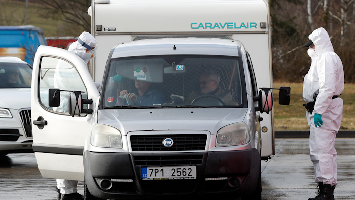 A member of the medical staff measures the temperature of a traveller at the border crossing with Germany in Rozvadov, Czech Republic, Monday, March 9, 2020. Czech authorities started on Monday random checks of arriving vehicles at the border crossings with Austria, Germany and Slovakia in reaction to the outbreak of the new coronavirus in Europe, particularly in Italy. As part of the move, officials measure the temperatures of some passengers in cars, trucks and buses.