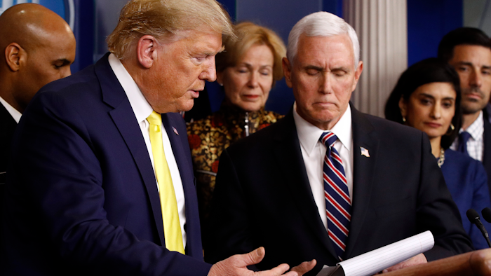 President Donald Trump gestures for Vice President Mike Pence to speaks in the briefing room of the White House in Washington, Monday, March 9, 2020, about the coronavirus outbreak.