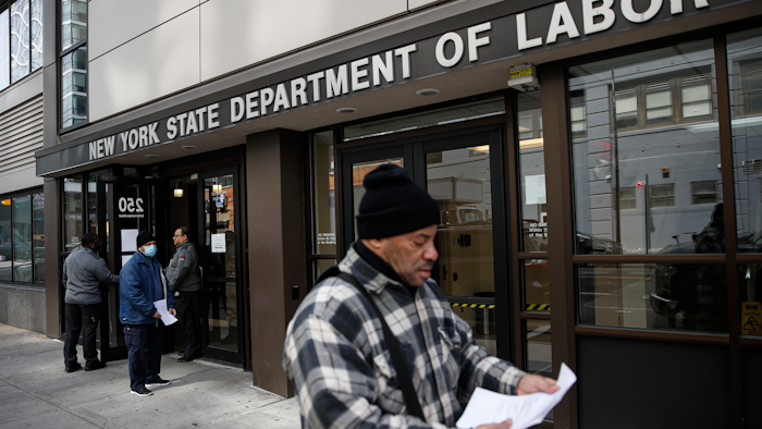 Visitors to the Department of Labor are turned away at the door by personnel due to closures over coronavirus concerns, Wednesday, March 18, 2020, in New York. Applications for jobless benefits are surging in some states as coronavirus concerns shake the U.S. economy. The sharp increase comes as governments have ordered millions of workers, students and shoppers to stay home as a precaution against spreading the virus that causes the COVID-19 disease.