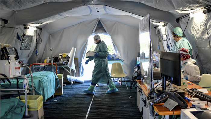 Medical personnel work inside one of the emergency structures that were set up to ease procedures outside the hospital of Brescia, Northern Italy, Tuesday, March 10, 2020.