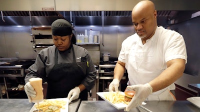 In this Jan. 29, 2020, photo, chef Samara Henderson, left, works with trainee Anthony Redmond at Inspiration Kitchens in Chicago.