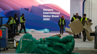 Workers dismantle a booth after that the 90th Geneva International Motor Show (GIMS) is cancelled by Swiss authorities, at the Palexpo in Geneva, Switzerland, Friday, Feb. 28, 2020. The 90th edition of the International Motor Show, scheduled to begin on March 5th, is cancelled due to the advancement of the (Covid-19) coronavirus in Switzerland. The Swiss confederation announced today that all events involving more than 1,000 people would be banned until 15 March.