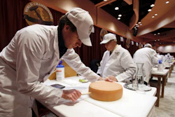Judge Douwe Dijkstra pulls out a piece of Appenzeller cheese at the biennial World Championship Cheese Contest, Tuesday, March 3, 2020, at the Monona Terrace Convention Center in Madison, Wis.