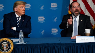 President Donald Trump listens as Secretary of Health and Human Services Alex Azar speaks during a briefing on the coronavirus at the National Institutes of Health, Tuesday, March 3, 2020, in Bethesda, Md.