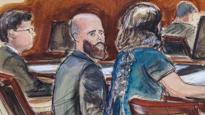 In this courtroom sketch Joshua Schulte, center, is seated at the defense table flanked by his attorneys during jury deliberations, Wednesday March 4, 2020, in New York. A federal jury in Manhattan has heard closing arguments in the espionage trial of Schulte, a former CIA software engineer charged in the largest leak of classified information in the agency's history.