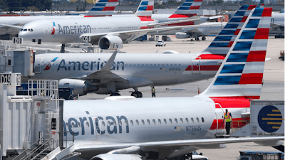In this April 24, 2019, photo, American Airlines aircraft are shown parked at their gates at Miami International Airport in Miami. A veteran airline mechanic has been sentenced to three years in prison for sabotaging an American Airlines jetliner in Miami with 150 people aboard. The lawyer for 60-year-old Abdul-Majeed Marouf Ahmed Alani said at a hearing Wednesday, March 4, 2020, that the mechanic's sole motive in July was to earn overtime fixing the plane.