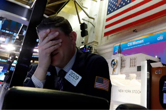 Trader Michael Gallucci prepares for the day's activity on the floor of the New York Stock Exchange, Monday, March 9, 2020. Trading in Wall Street futures has been halted after they fell by more than the daily limit of 5%.