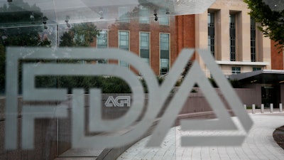 This Aug. 2, 2018, file photo shows the U.S. Food and Drug Administration building behind FDA logos at a bus stop on the agency's campus in Silver Spring, Md.