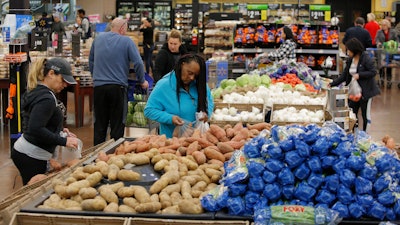 In this Nov. 27, 2019, file photo people shop for food the day before the Thanksgiving holiday at a Walmart Supercenter in Las Vegas.