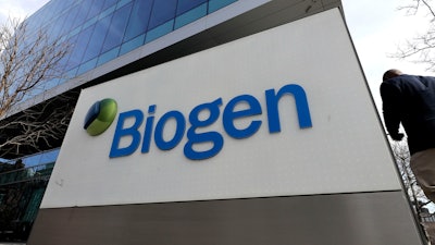 A man walks outside the Biogen Inc., headquarters, Wednesday, March 11, 2020, in Cambridge, Mass.
