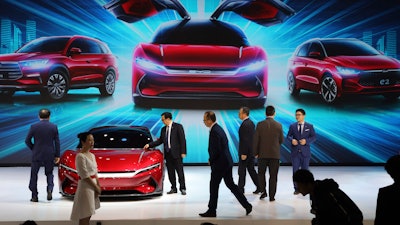 In this April 16, 2019, file photo, attendees take a close look at cars from BYD at the Auto Shanghai 2019 show in Shanghai. China’s auto sales plunged 81.7% in February, 2020, from a year ago after Beijing shut down much of the economy to fight a virus outbreak, adding to problems for an industry that already was struggling with shrinking demand.
