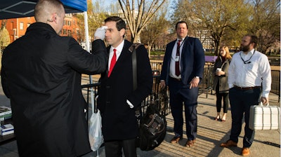 Journalists and White House staff's body temperature are checked by White House medical staff before they enter the White House perimeter, Monday, March 16, 2020, in Washington.