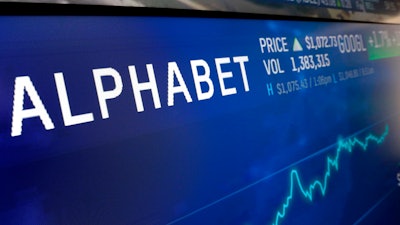 In this Feb. 14, 2018, file photo the logo for Alphabet appears on a screen at the Nasdaq MarketSite in New York. Google sister company Verily has launched a website to screen people who think they might have COVID-19 and point them to testing sites, but you probably still can't get tested. Verily, a health tech company owned by Google parent Alphabet, launched the screening tool Sunday, March 15, 2020 for those that live in or near Santa Clara County and San Mateo County in California's Silicon Valley.